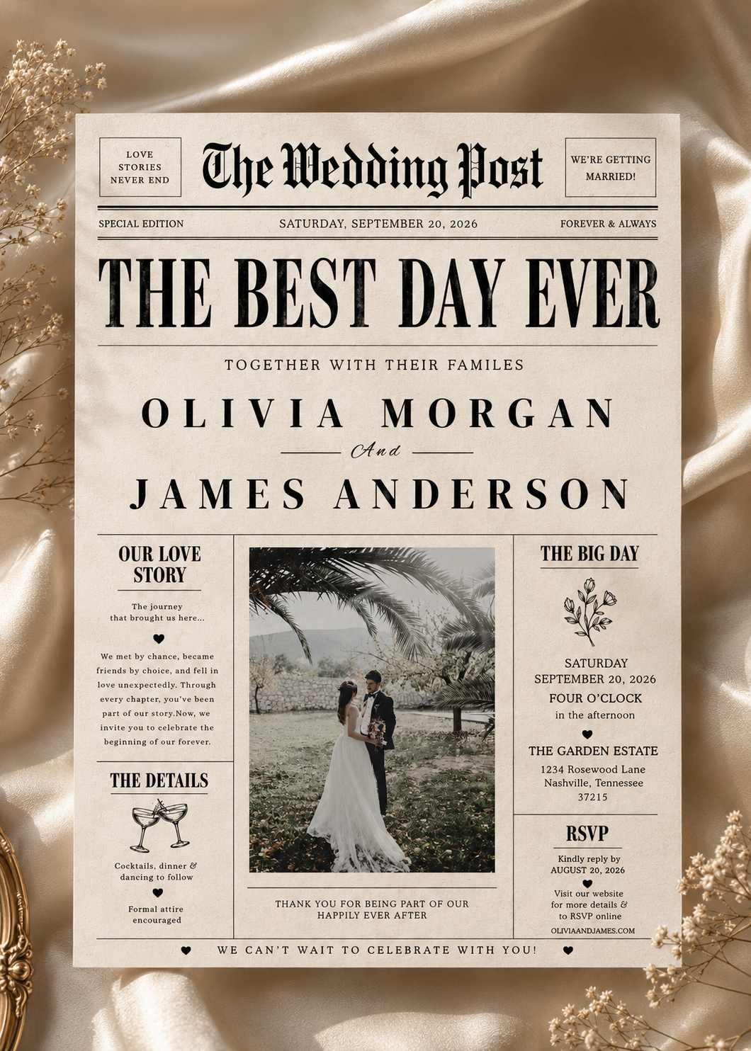 A square wedding invitation styled like a vintage newspaper front page titled "The Wedding Post," with black serif text on an off-white background and a central wedding photo. The invitation is centered on a draped champagne satin fabric with dried floral accents at the corners.