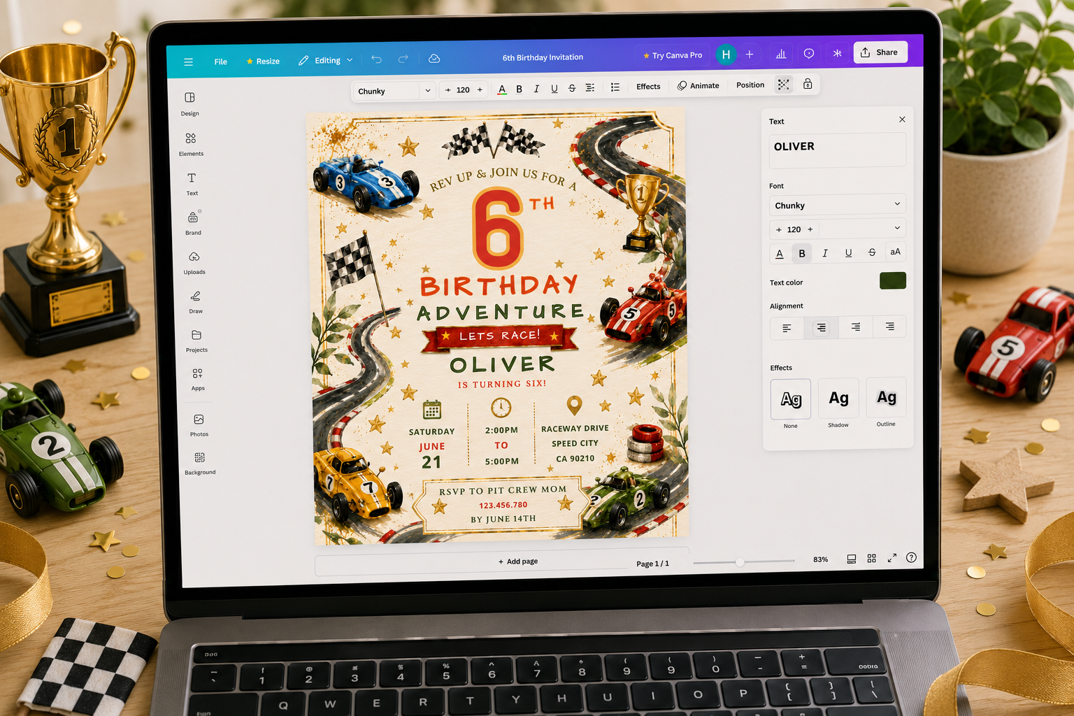 A laptop on a wooden desk displaying a race-themed 6th birthday invitation template. The scene is styled with miniature racing props, including toy race cars, a gold trophy, checkered paper, and a small potted plant.