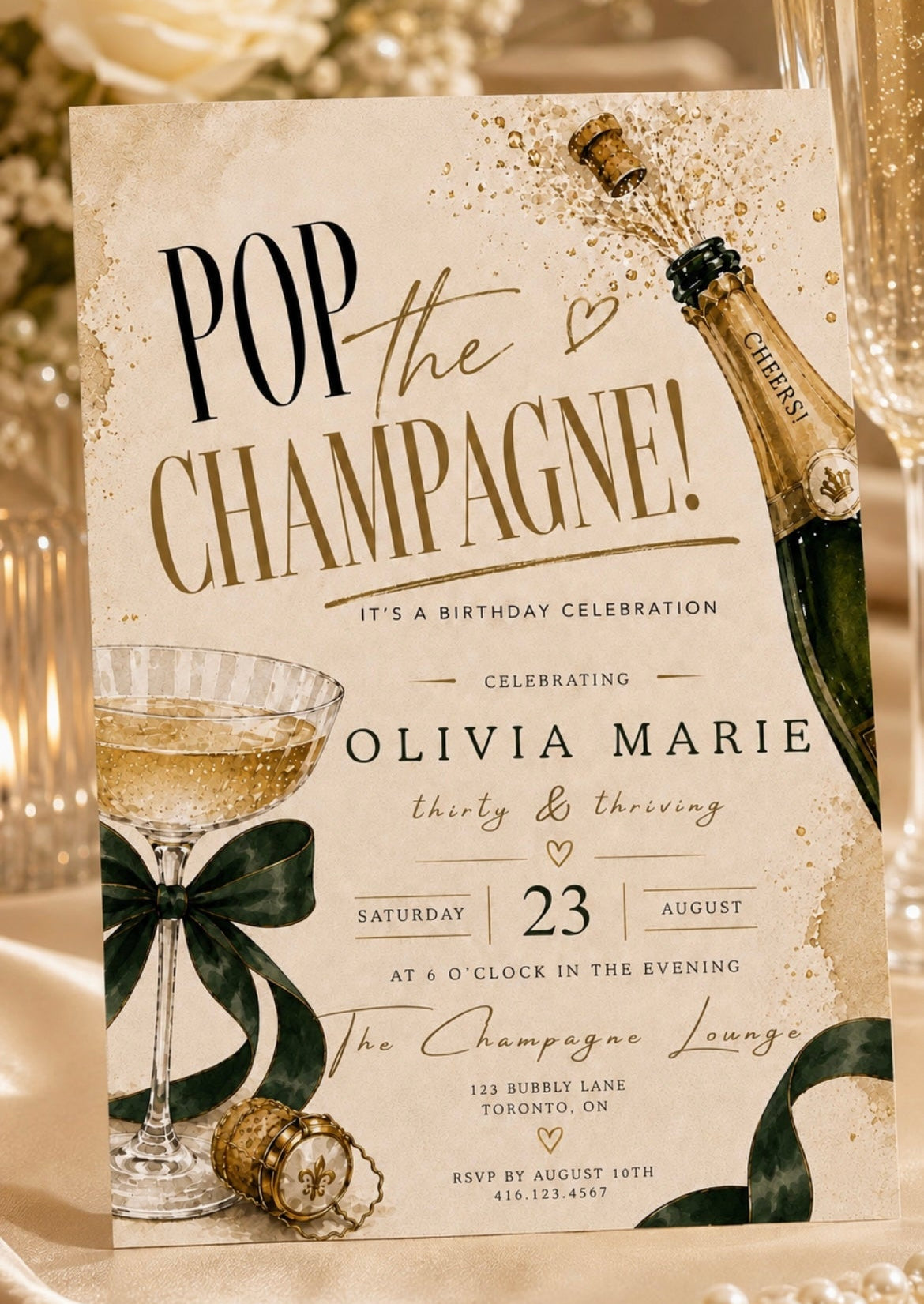 Champagne party invitation with gold bottle emerald ribbon and sparkling coupe glass