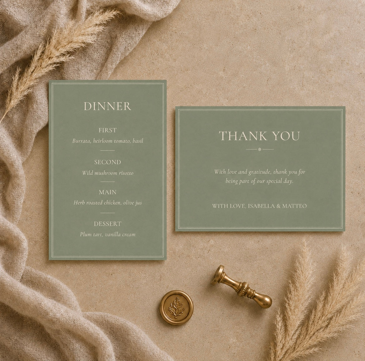 A flat-lay of a dinner invitation suite featuring a sage green 'Dinner' menu card and a matching 'Thank You' card on a textured beige background, styled with a cream knit blanket, dried pampas grass, and a gold wax seal stamp.