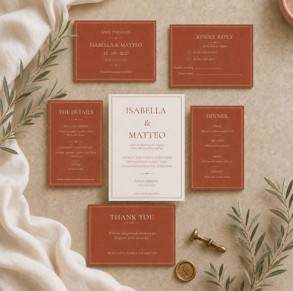 A coordinated wedding stationery set arranged on a beige fabric surface with decorative greenery and a wax seal. The set includes a central white invitation card and five terracotta-colored cards: save the date, wedding day reply, details, dinner, and thank you.
