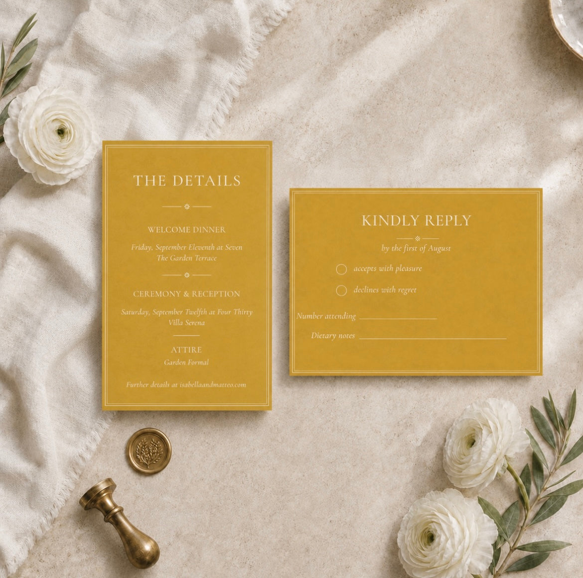 A styled flat-lay of a mustard yellow wedding invitation suite, featuring a 'The Details' card and a 'Kindly Reply' card on a textured beige linen background with white flowers and a gold wax seal.