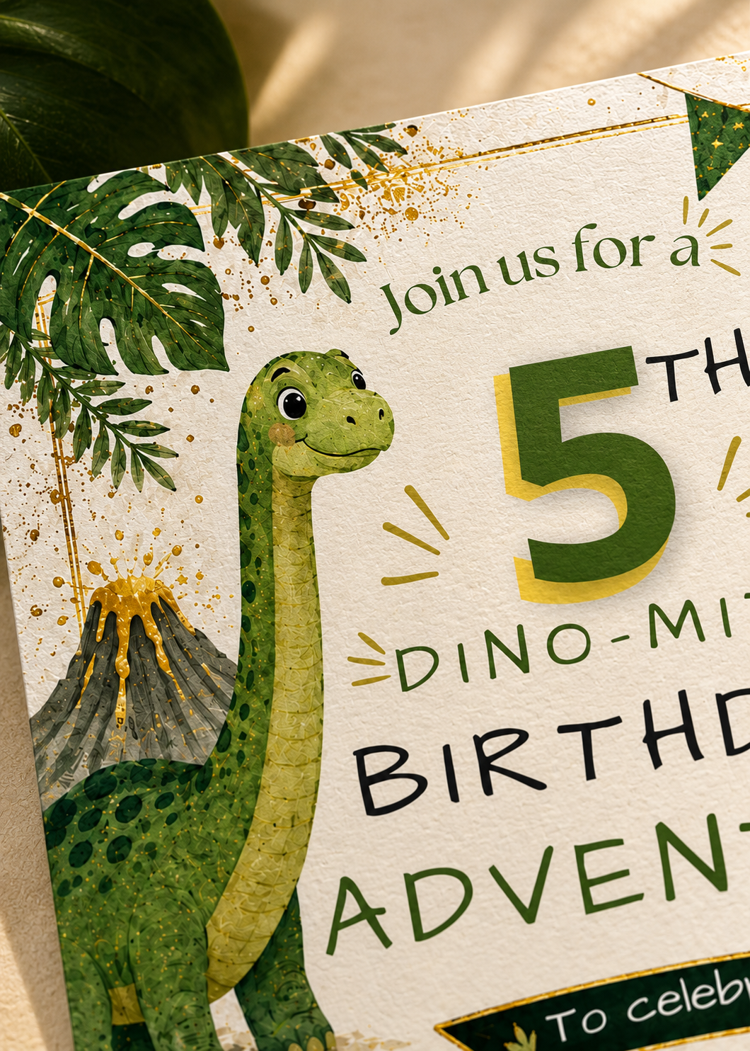 A close-up of a dinosaur-themed birthday invitation card with a green long-necked dinosaur, palm leaves, a volcano, and large text reading 'Join us for a 5th Dino-Mini Birthday Advent To celebrate'.